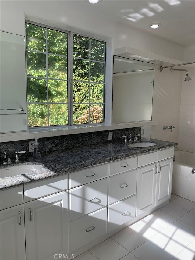 bathroom featuring vanity, backsplash, tile patterned floors, and shower / tub combination