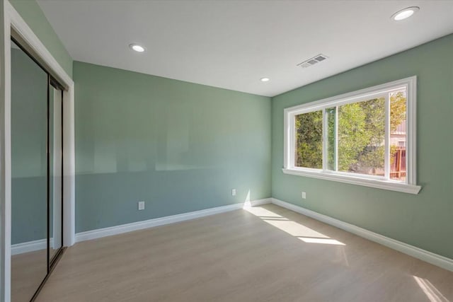 unfurnished bedroom with a closet and light hardwood / wood-style flooring