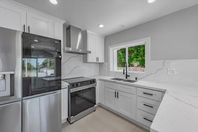 kitchen featuring white cabinetry, sink, wall chimney range hood, and appliances with stainless steel finishes