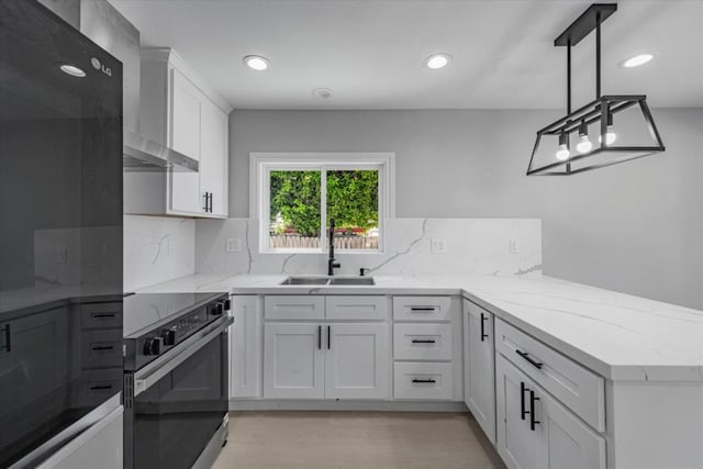 kitchen with white cabinets, sink, hanging light fixtures, kitchen peninsula, and stove