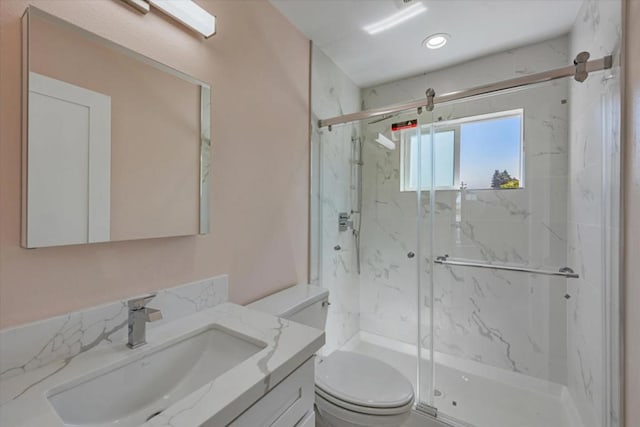 bathroom with a shower with shower door, toilet, and vanity