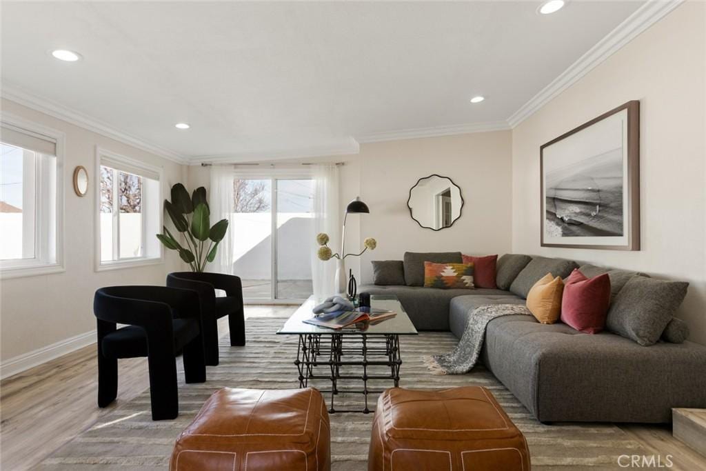 living room with crown molding and light hardwood / wood-style floors