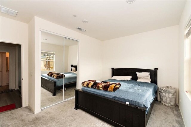 bedroom featuring a closet and light colored carpet