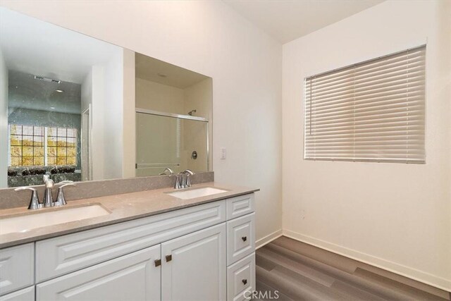 bathroom with a shower with shower door, vanity, and hardwood / wood-style floors