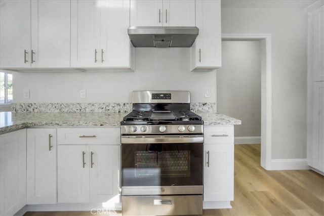 kitchen featuring white cabinets, stainless steel gas range oven, and range hood