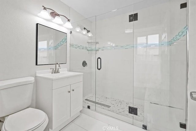 bathroom with tile patterned floors, toilet, vanity, and walk in shower