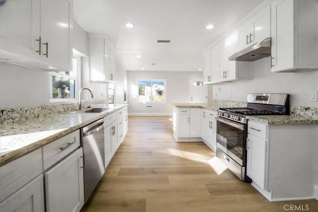 kitchen with light hardwood / wood-style floors, white cabinetry, sink, and appliances with stainless steel finishes