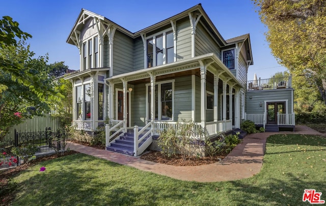 victorian-style house with covered porch and a front lawn