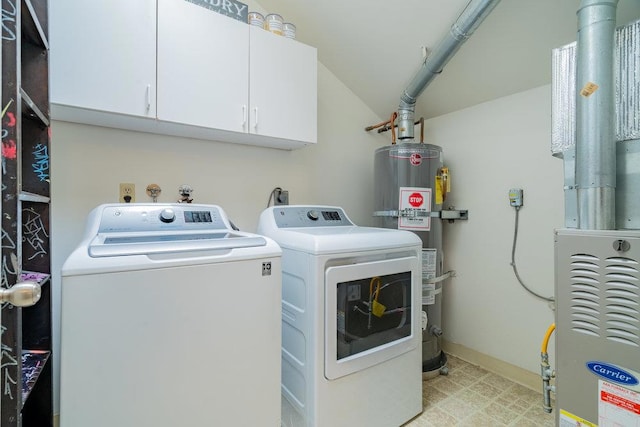 clothes washing area featuring cabinets, washer and dryer, and strapped water heater