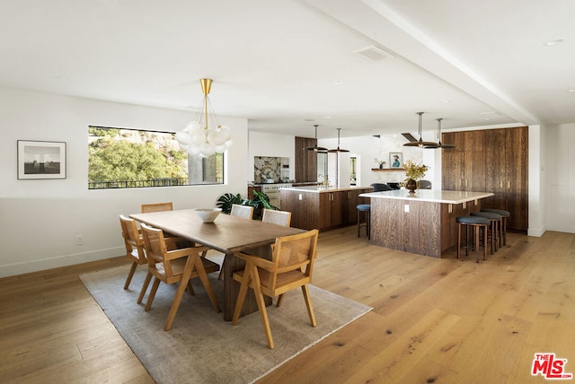 dining space featuring light hardwood / wood-style flooring and a notable chandelier