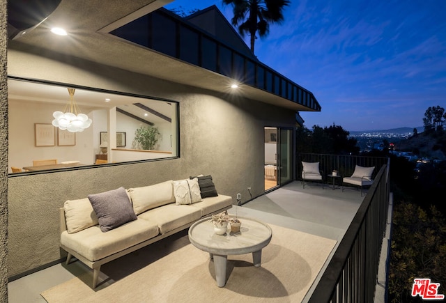 patio terrace at dusk featuring a balcony and outdoor lounge area