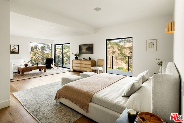 bedroom with light hardwood / wood-style floors and access to outside