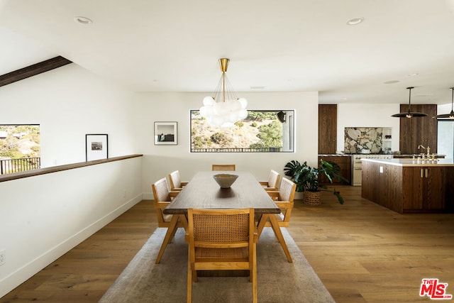 dining room with light hardwood / wood-style flooring and a notable chandelier