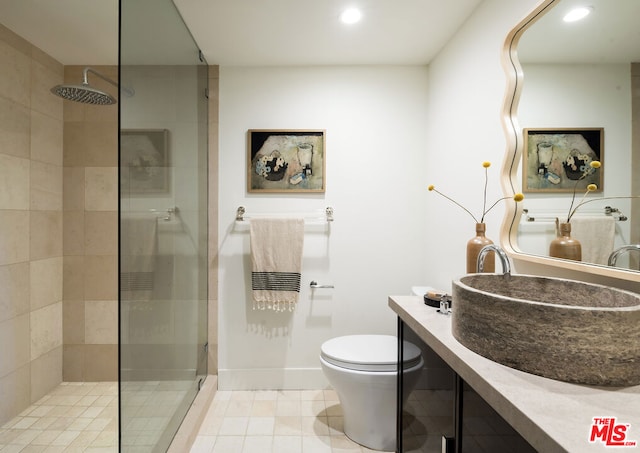 bathroom with toilet, vanity, and tiled shower