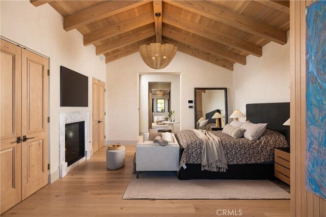 bedroom featuring wood ceiling, lofted ceiling with beams, and light wood-type flooring