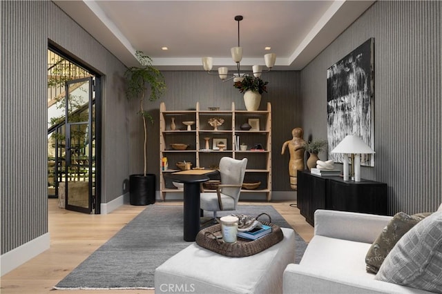 living area with an inviting chandelier and light hardwood / wood-style floors