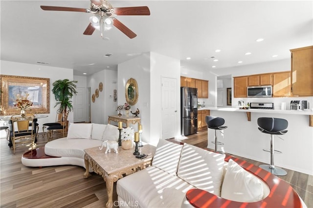 living room with ceiling fan and light hardwood / wood-style flooring