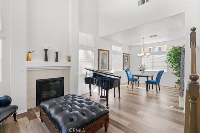 sitting room with a chandelier, a fireplace, and hardwood / wood-style floors