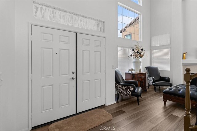 entrance foyer with light wood-type flooring and a towering ceiling