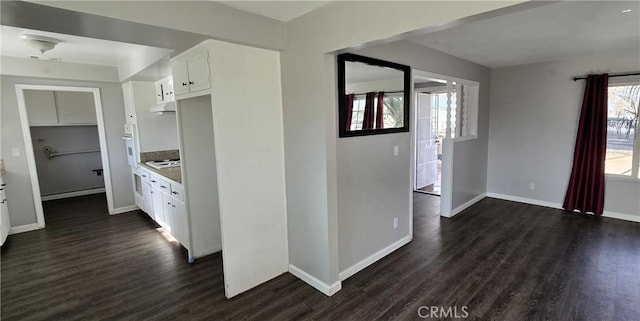 kitchen with white cabinets, plenty of natural light, cooktop, and dark hardwood / wood-style floors