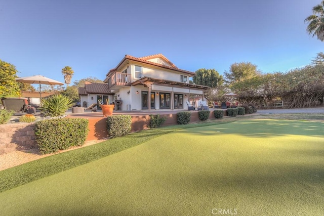 rear view of property featuring a balcony