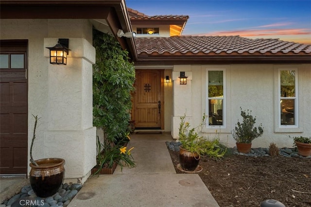 exterior entry at dusk with a garage