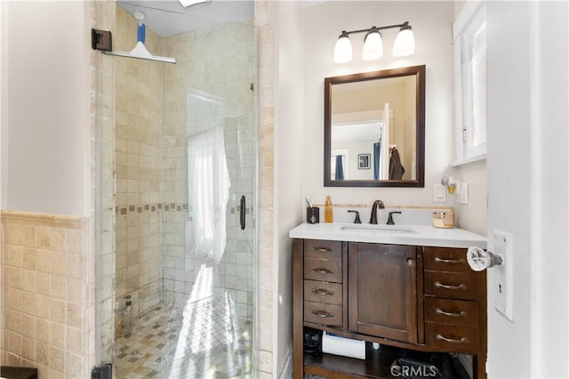 bathroom featuring walk in shower, vanity, and tile walls