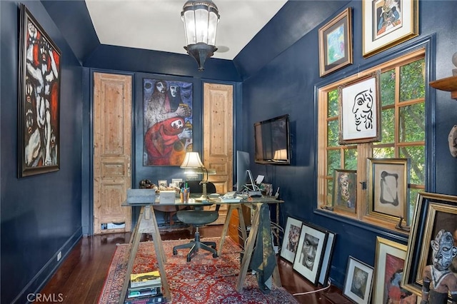 office space featuring dark wood-type flooring, a notable chandelier, and vaulted ceiling