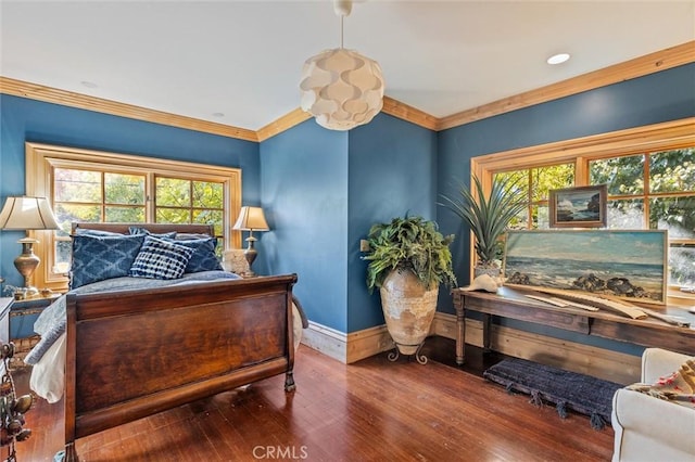 bedroom featuring wood-type flooring, multiple windows, and ornamental molding