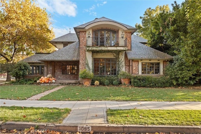 view of front of property with a front yard and a balcony