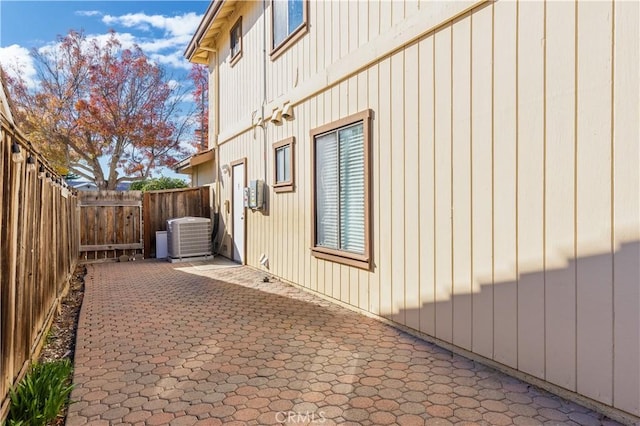 view of side of home featuring a patio area and cooling unit