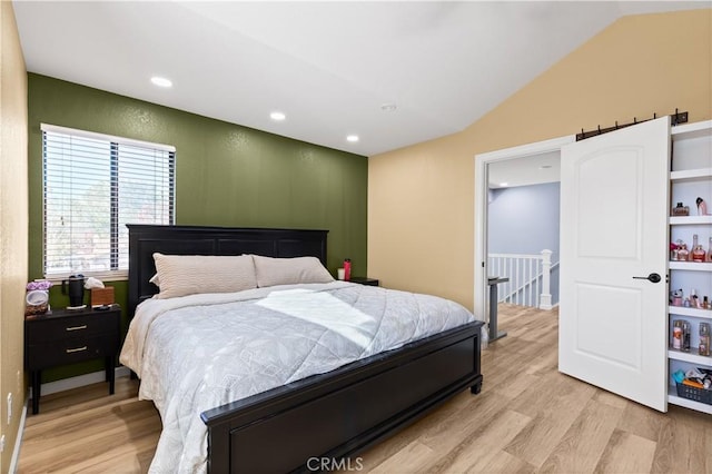 bedroom featuring lofted ceiling and light hardwood / wood-style floors