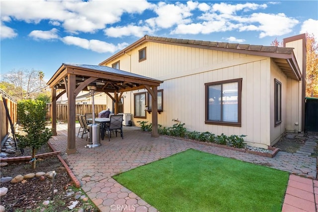 back of property featuring a gazebo and a patio