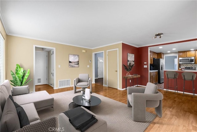 living room with ornamental molding and light wood-type flooring