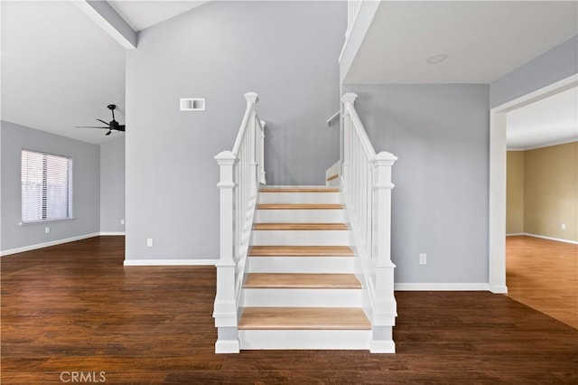 stairway featuring ceiling fan, hardwood / wood-style floors, and vaulted ceiling