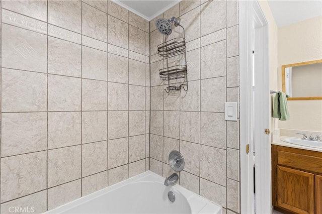 bathroom with tiled shower / bath combo, vanity, and ornamental molding