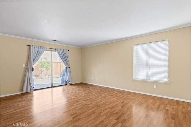 spare room featuring light hardwood / wood-style floors and crown molding