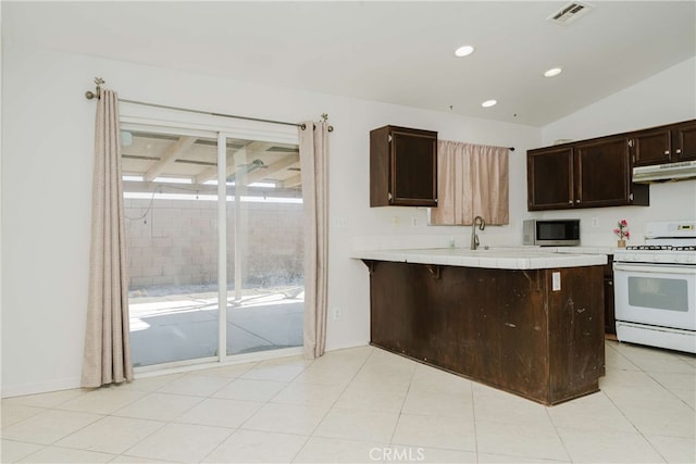 kitchen featuring a healthy amount of sunlight, kitchen peninsula, a breakfast bar, and white range oven