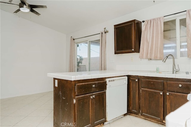 kitchen with kitchen peninsula, ceiling fan, dishwasher, dark brown cabinetry, and sink