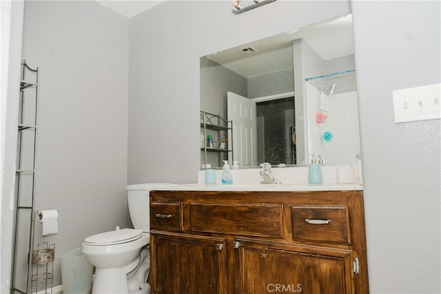 bathroom with toilet, walk in shower, and vanity