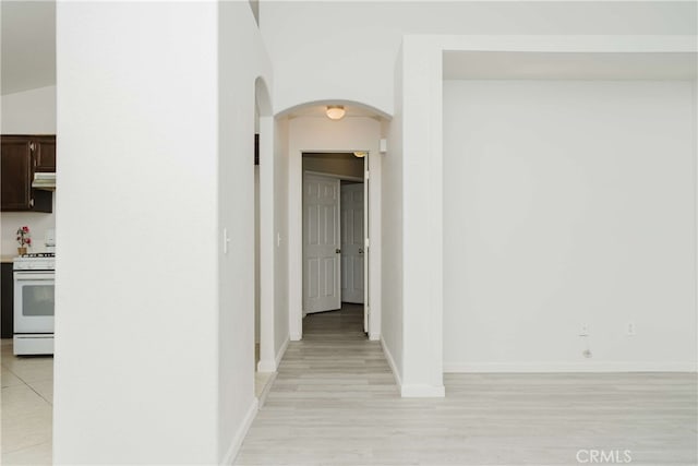 hall with light hardwood / wood-style flooring and lofted ceiling