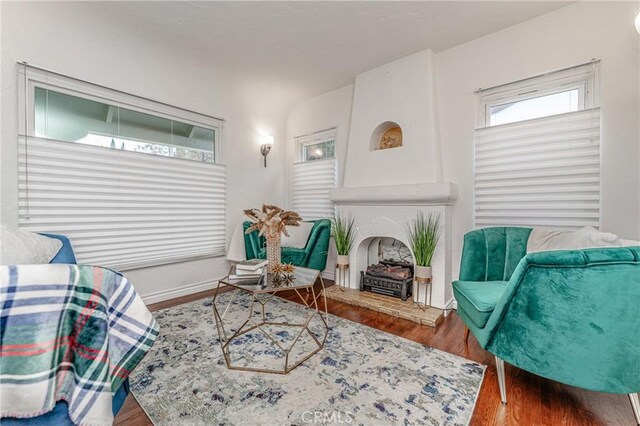 sitting room featuring a large fireplace and hardwood / wood-style flooring