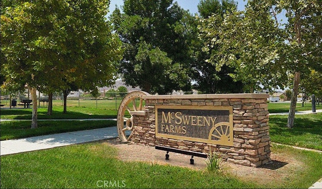 community / neighborhood sign featuring a lawn