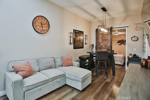 living room featuring dark wood-type flooring and an inviting chandelier