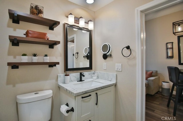 bathroom featuring toilet, vanity, and hardwood / wood-style floors