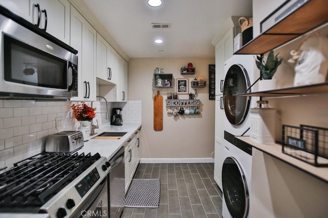 laundry room featuring stacked washer / dryer and sink