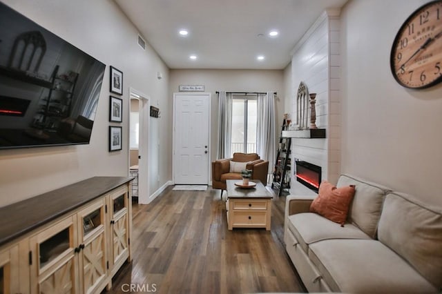 living room with dark wood-type flooring and a fireplace