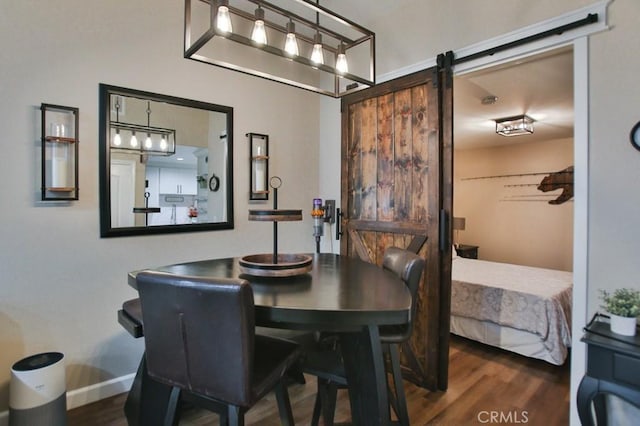 dining space featuring a barn door and dark hardwood / wood-style floors