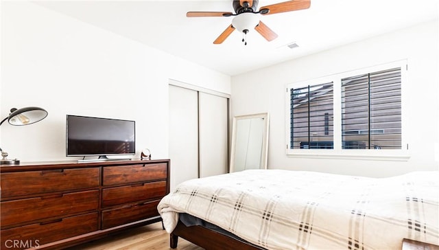 bedroom featuring ceiling fan, a closet, and light hardwood / wood-style flooring