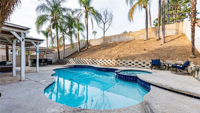 view of swimming pool with a patio area, a grill, and an in ground hot tub